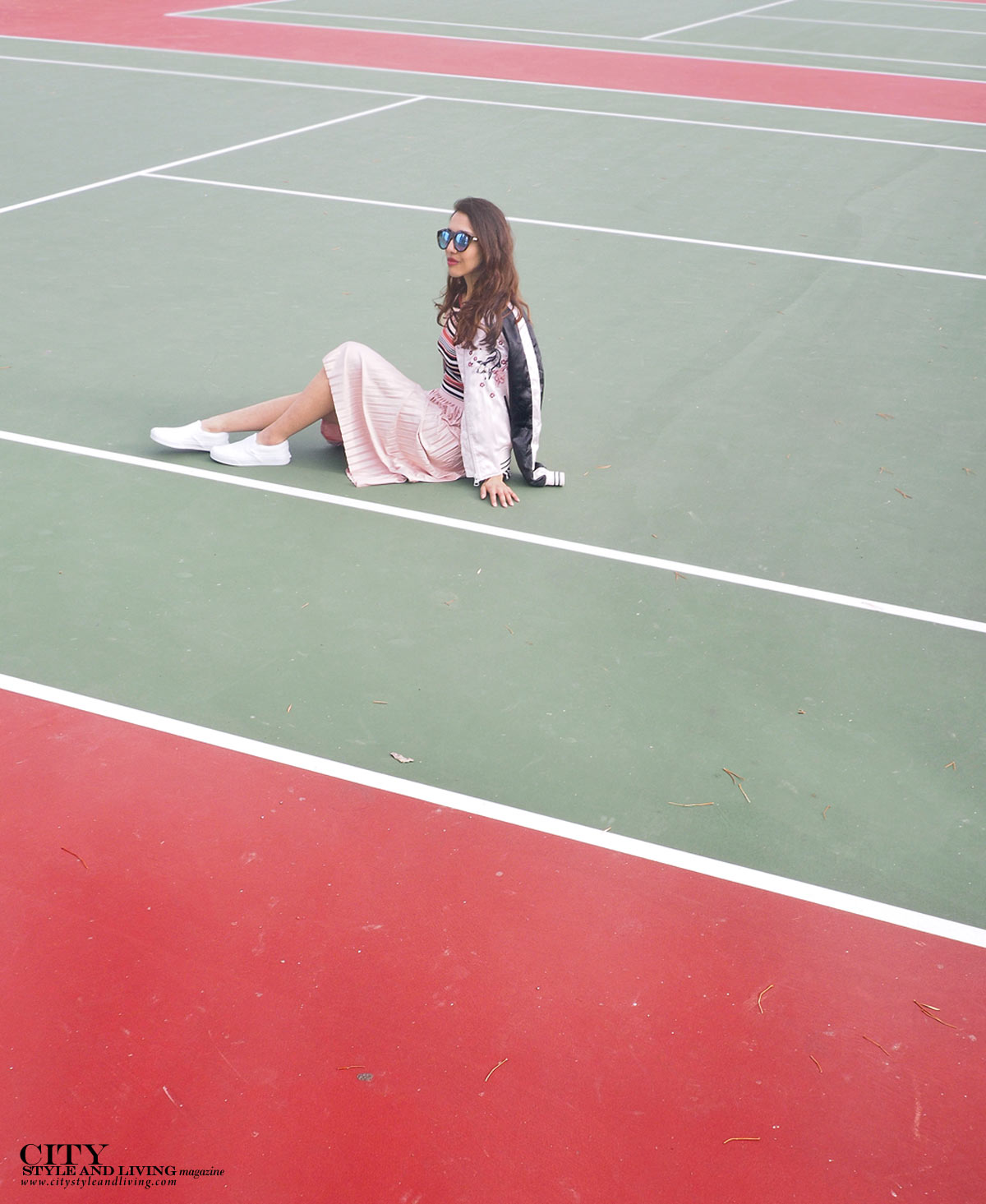 City STyle and Living The Editors Notebook style blogger tennis court topshop metallic skirt, off shoulder free people top, le specs sunglasses and white sneakers and topshop bomber jacket sitting at court