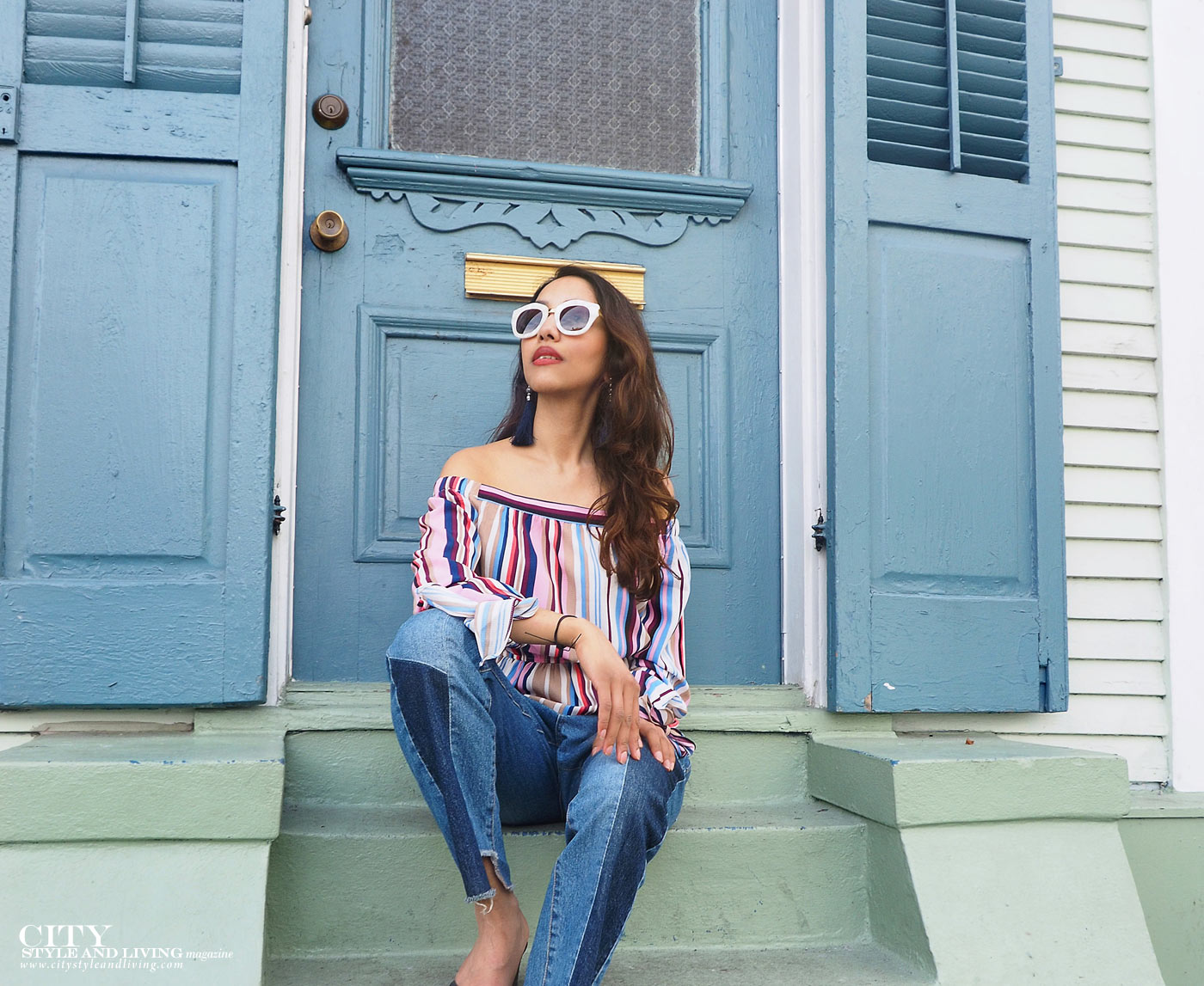 City style and living magazine The Editors Notebook style fashion blogger Shivana Maharaj New Orleans French Quarter Off shoulder top and ankle biter jeans sitting on steps